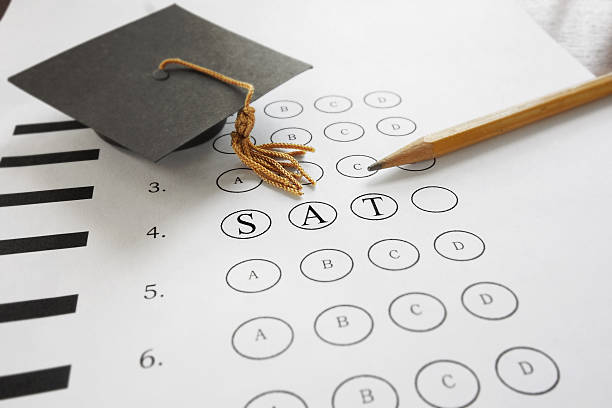 SAT test with pencil and mortar board graduation cap